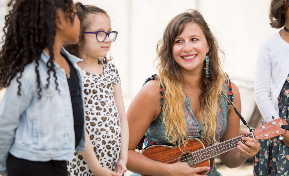 image of woman playing ukulele with children